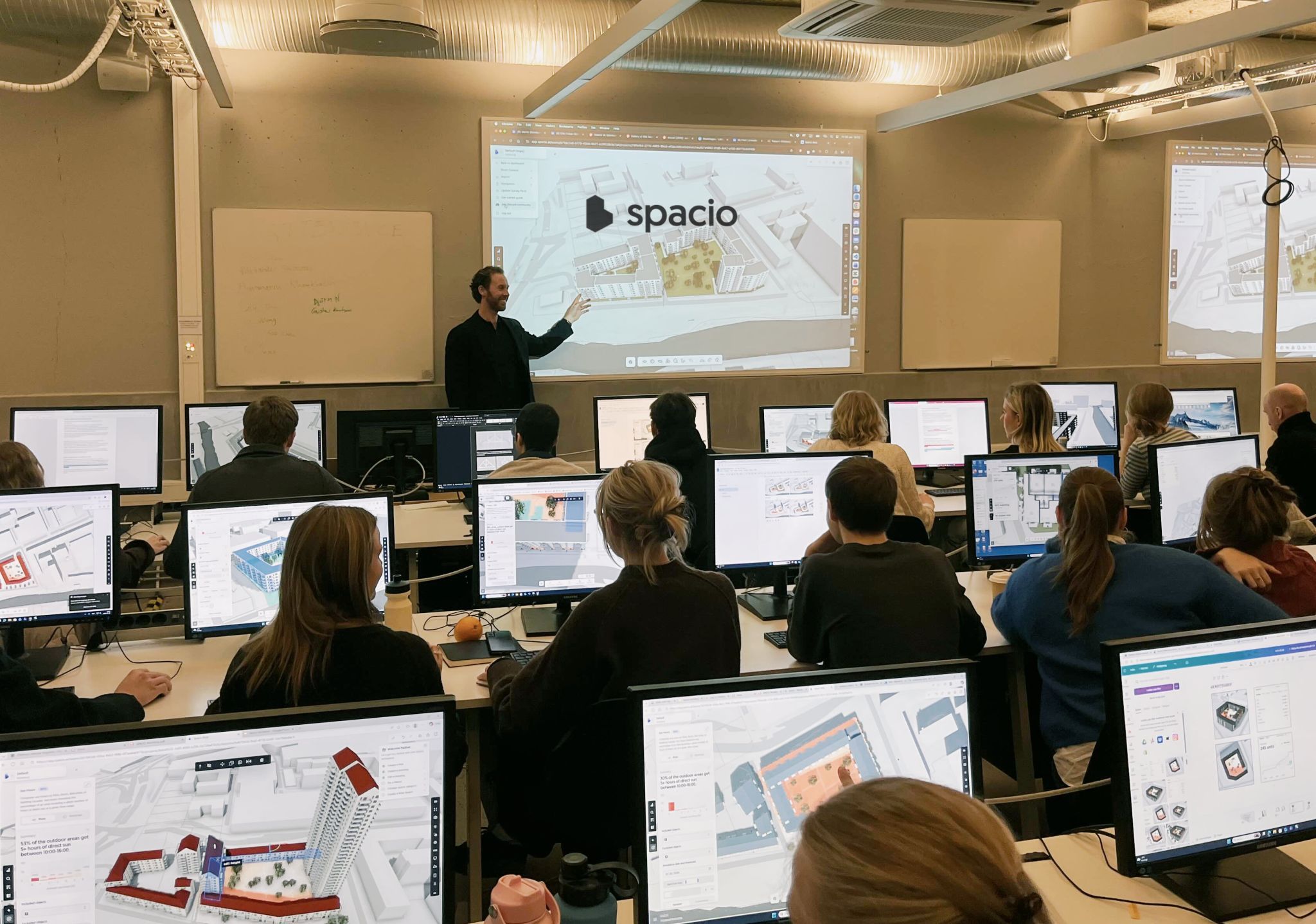 Architecture students using Spacio on their computers during a workshop, with Spacio projected on screen